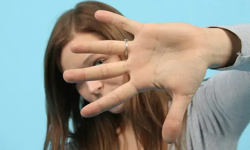 Frau hält Hand vor ihr Gesicht