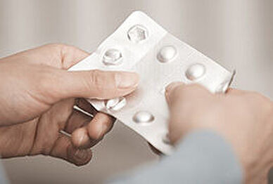 Hände die eine Tablettenpackung halten