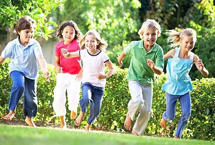 Gruppe von laufenden Kindern auf einer Wiese