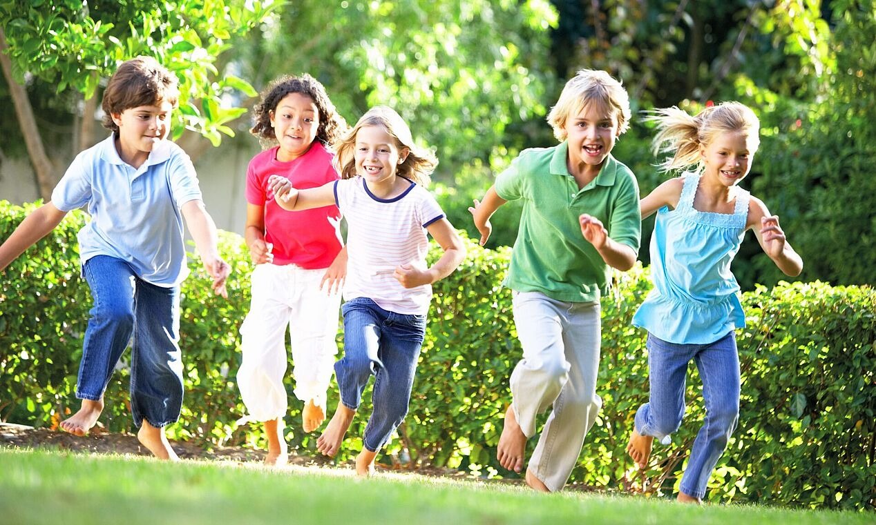 Gruppe von laufenden Kindern auf einer Wiese