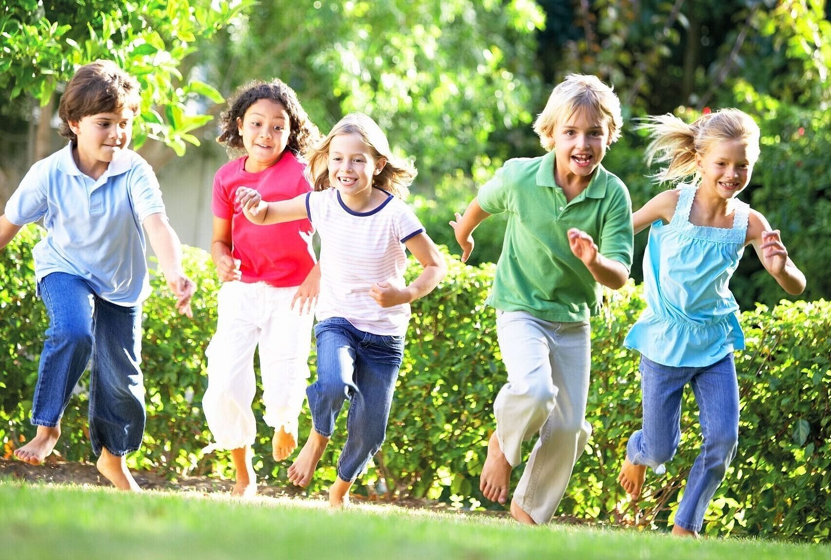 Gruppe von laufenden Kindern auf einer Wiese