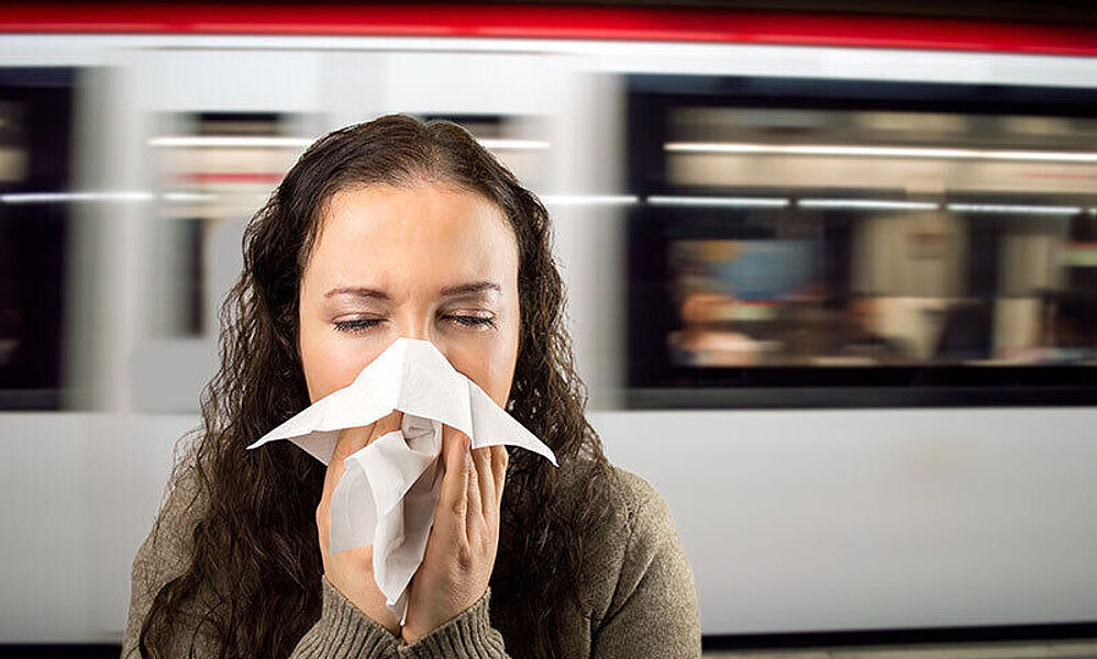 Frau putzt sich am Bahnhof die Nase (© iStock.com / Manuel-F-O)