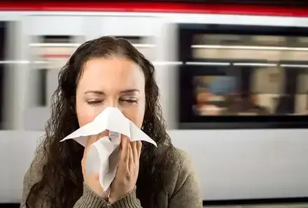 Frau putzt sich am Bahnhof die Nase (© iStock.com / Manuel-F-O)