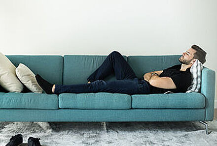 Mann liegt auf der Couch