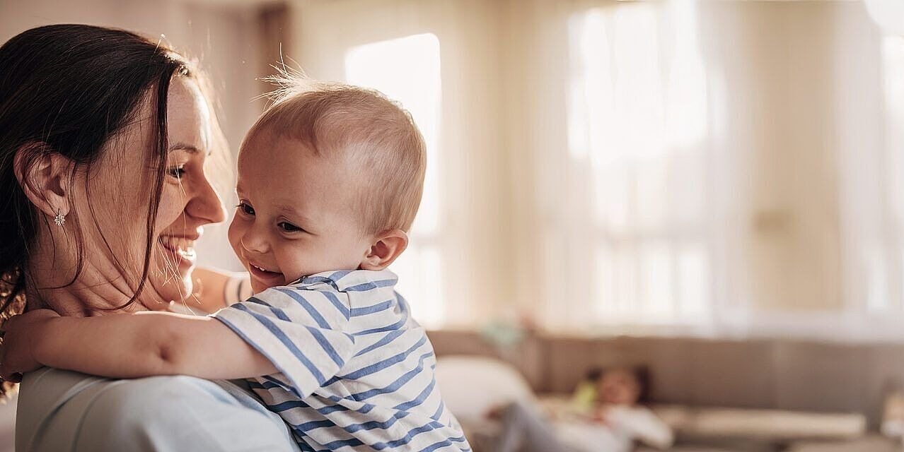 Frau hält Baby auf dem Arm