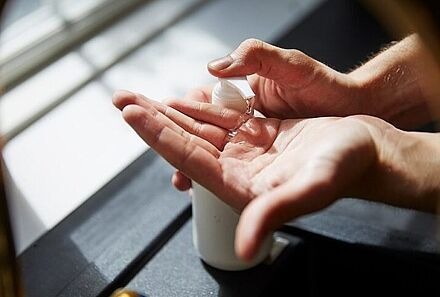 Hände, auf denen Handdesinfektionsmittel aufgetragen wird