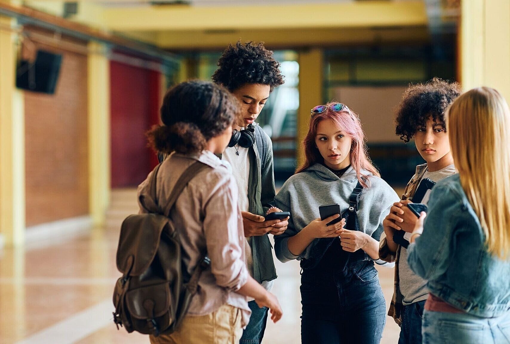 Gruppe von Jugendlichen steht in einem Foyer zusammen