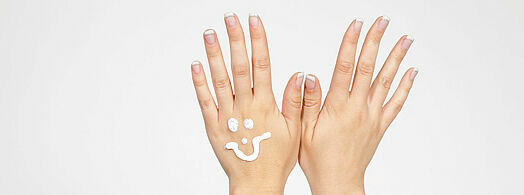 Hände mit lachendem Gesicht aus Creme (© Kristin Gründler / Fotolia)