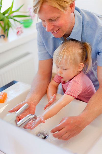 Kind und Vater waschen sich die Hände (© Hengelein and Steets / Science Photo Library)